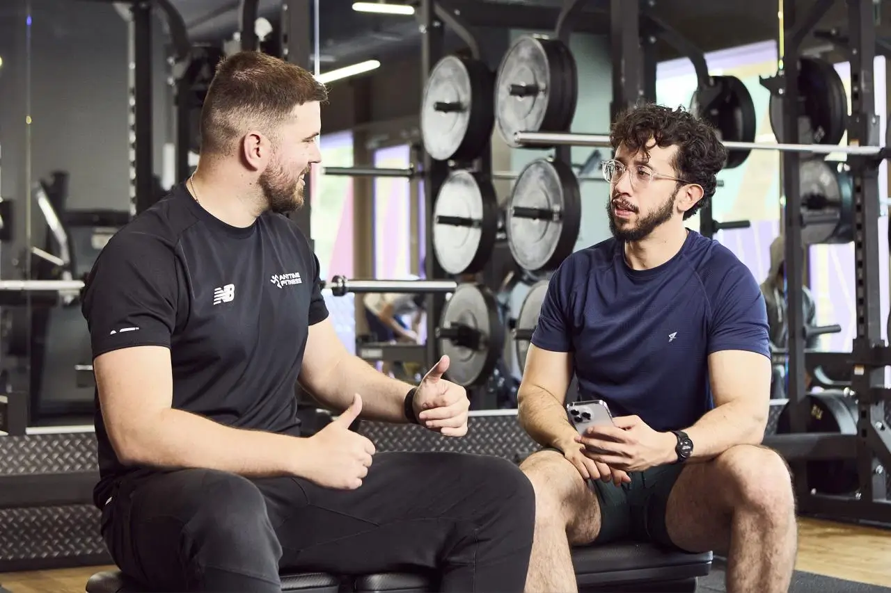 Gerald Latifi discussing structured training with a client in the gym