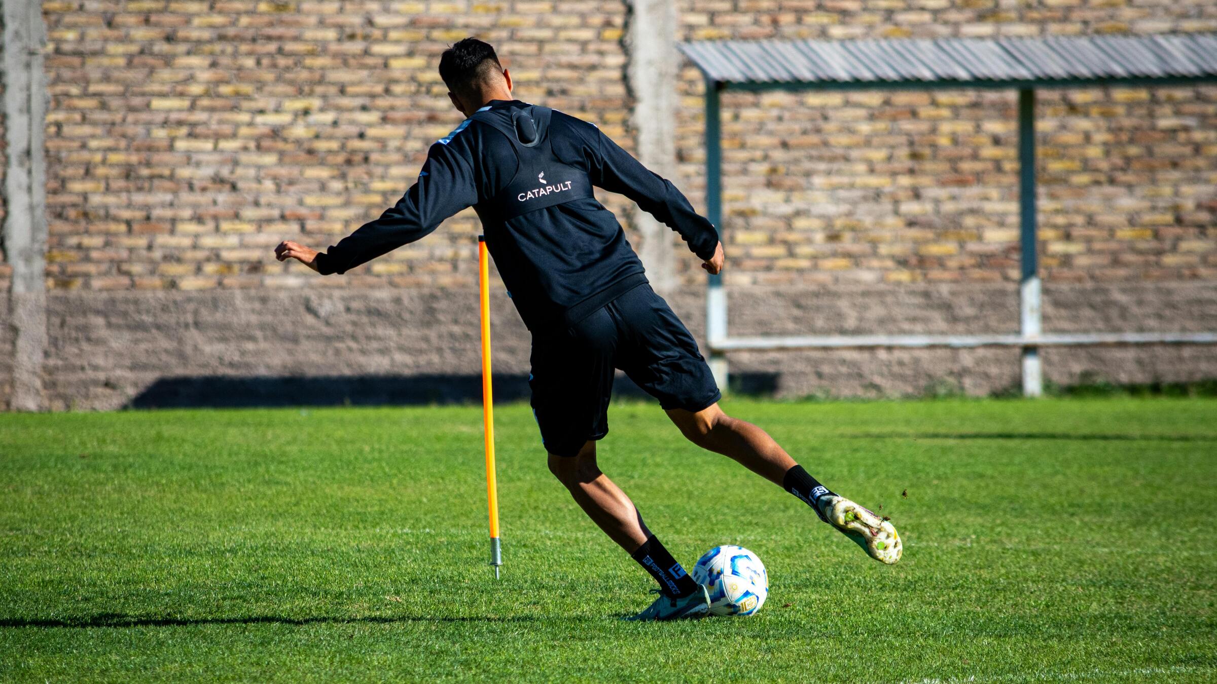 Football player performing a dynamic match action on the pitch
